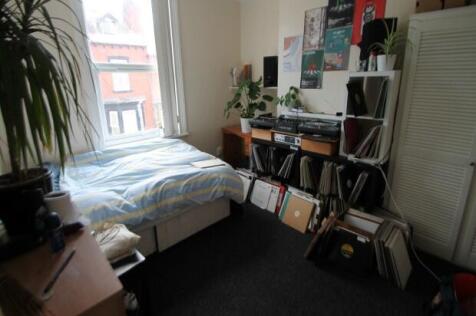 A cozy living space featuring a bed, desk area,...