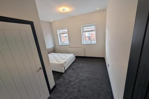 Spacious modern bedroom with plush grey carpet...