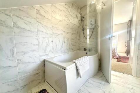 Elegant marble-effect bathroom with modern bath...
