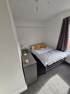 A neat and bright bedroom featuring a comfortab...