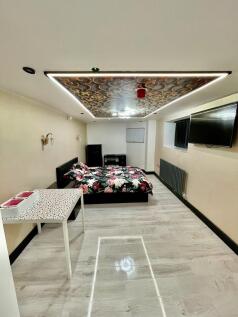 Spacious bedroom with double bed and wall TV...