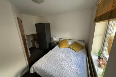 Bright double bedroom featuring a comfortable d...