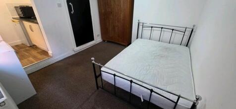 Neat, simply furnished bedroom featuring a meta...