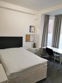 Bright, uncluttered bedroom with a comfortable ...