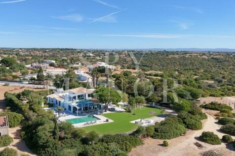 Aerial view of a detached villa with swimming pool and large plot in Caramujeira.