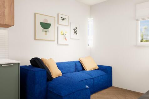 Bright, modern living area with a deep blue sof...