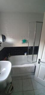 Bright, modern bathroom with white and dark til...