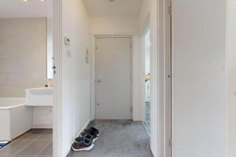 Bright, neutral hallway with soft carpeting, a ...