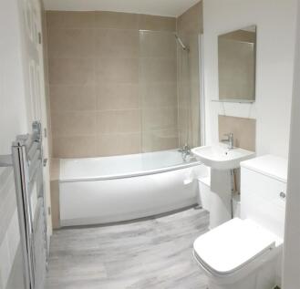 Modern bathroom with full tub and stylish tilin...