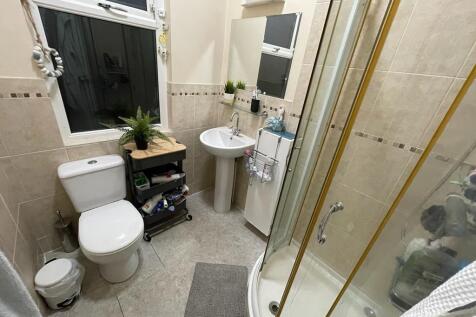 Well-maintained bathroom with a curved glass sh...