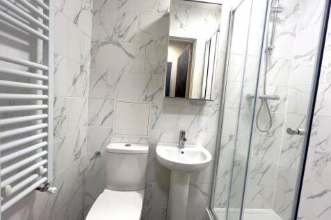 Modern bathroom featuring white marble-patterne...