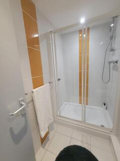 Fresh, modern bathroom with a tiled shower encl...