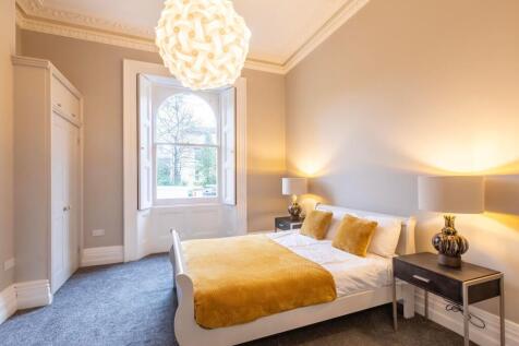 Bright, stylish bedroom with a large arched sas...