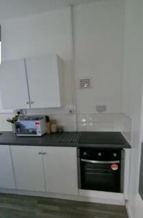 A neat and functional kitchen featuring white c...