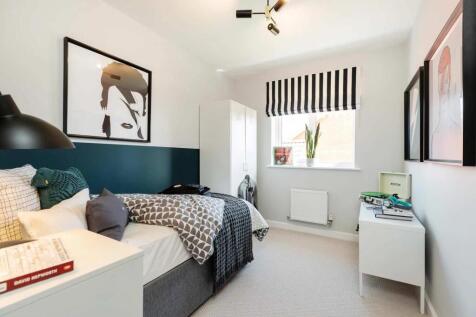 A cozy and stylish bedroom with a framed artwork, striped curtains
