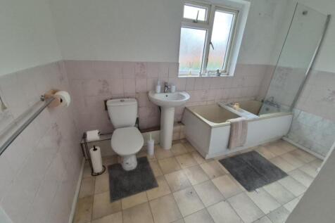 Bright, spacious bathroom with bathtub and show...