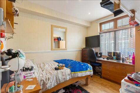 This inviting double bedroom features warm wood...