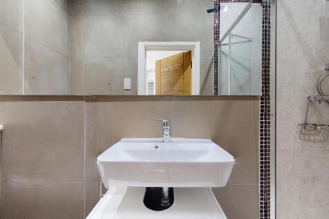 Modern tiled bathroom with sink and shower...
