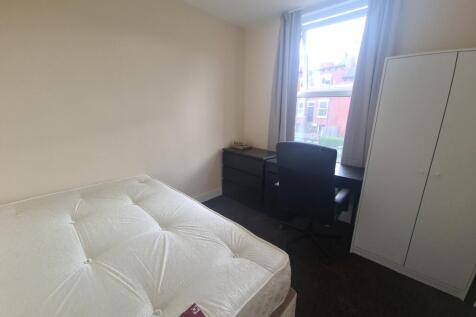 A spacious master bedroom featuring a large bed...