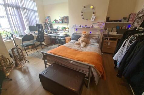 A spacious and well-lit master bedroom featurin...