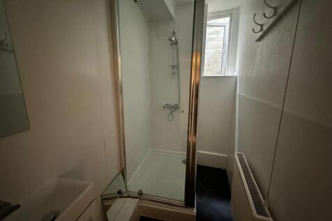 Compact bathroom with an enclosed shower cubicl...