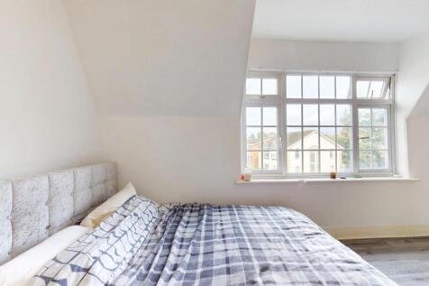 Bright bedroom with a large window and comfy be...