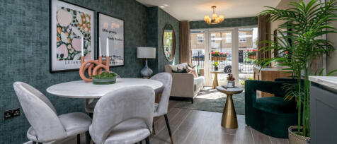 Modern living room with dark green textured walls, grey furniture, gold accents, and large glass doo
