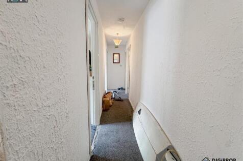 Bright and neutral hallway with soft carpeting...
