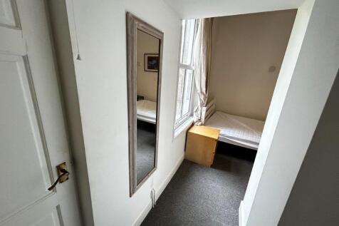 Bright bedroom with tall window and full mirror...
