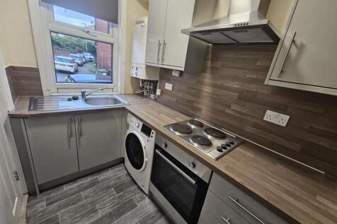 Neat fitted kitchen with wood-effect worktops, ...