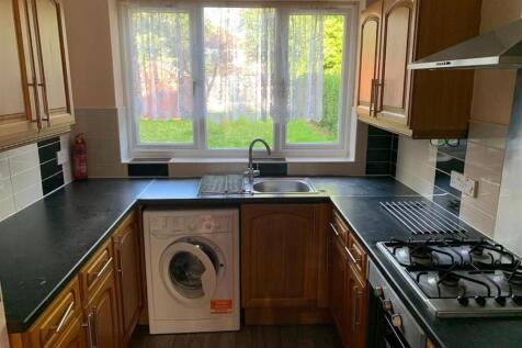 Bright galley kitchen with a wide window over t...