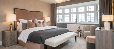 Elegant bedroom with large bay window, modern decor, beige and grey tones, and a neatly made bed wit