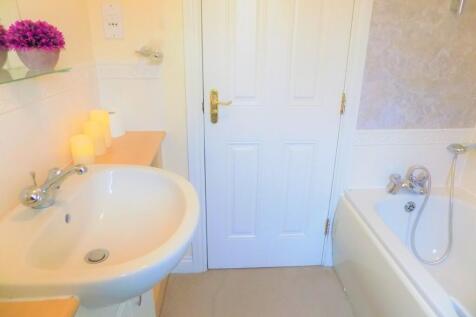 A bright and clean bathroom suite featuring a w...