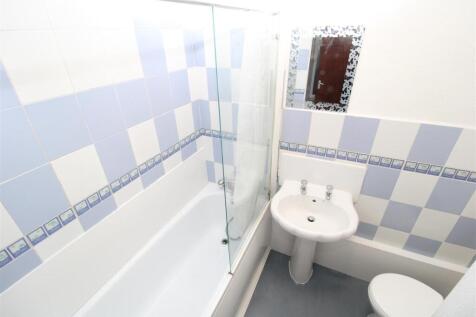 Bright bathroom suite with bath and shower scre...