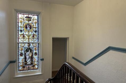 Well-maintained stairwell with decorative stain...