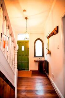 Welcoming entrance with wooden floors and coat ...