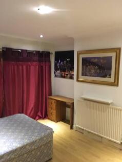 Bright, simply furnished bedroom with wooden fl...