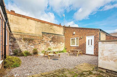 Private paved courtyard with two picnic benches...