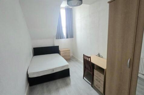 Bright, simply furnished bedroom with bed and d...