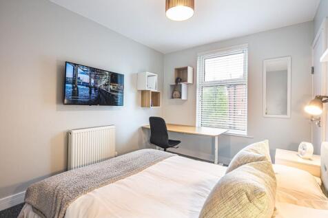 Bright and modern living room featuring a wall-...