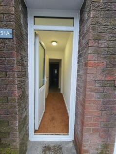 Bright entrance hallway with secure white door....