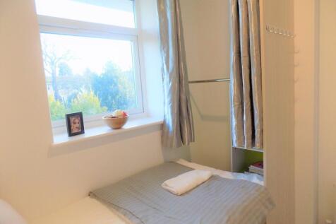 Bright single bedroom with a large window provi...