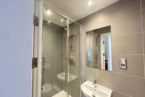 Modern tiled ensuite with sleek glass shower...