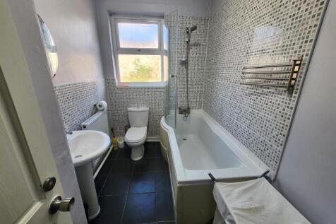 Modern bathroom with patterned tile walls, whit...