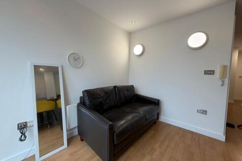 Contemporary living area with a black leather t...