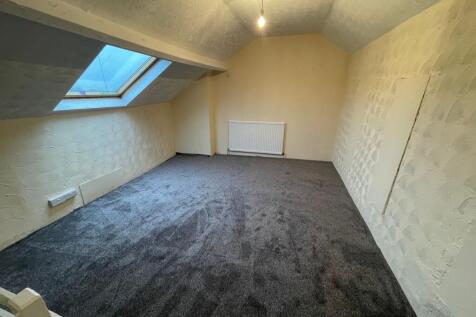 Bright attic room with plush dark grey carpet...