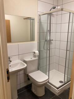 Bright, modern bathroom with a tiled corner sho...