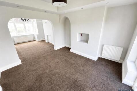 Spacious open-plan living room with natural lig...