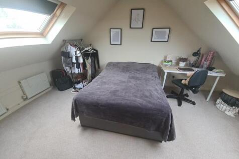 A spacious and well-lit master bedroom featurin...