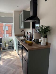 Bright, modern kitchenette with stylish sage-gr...